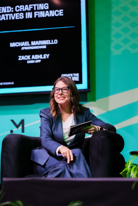 Team member seated on stage as a panelist at a financial services conference